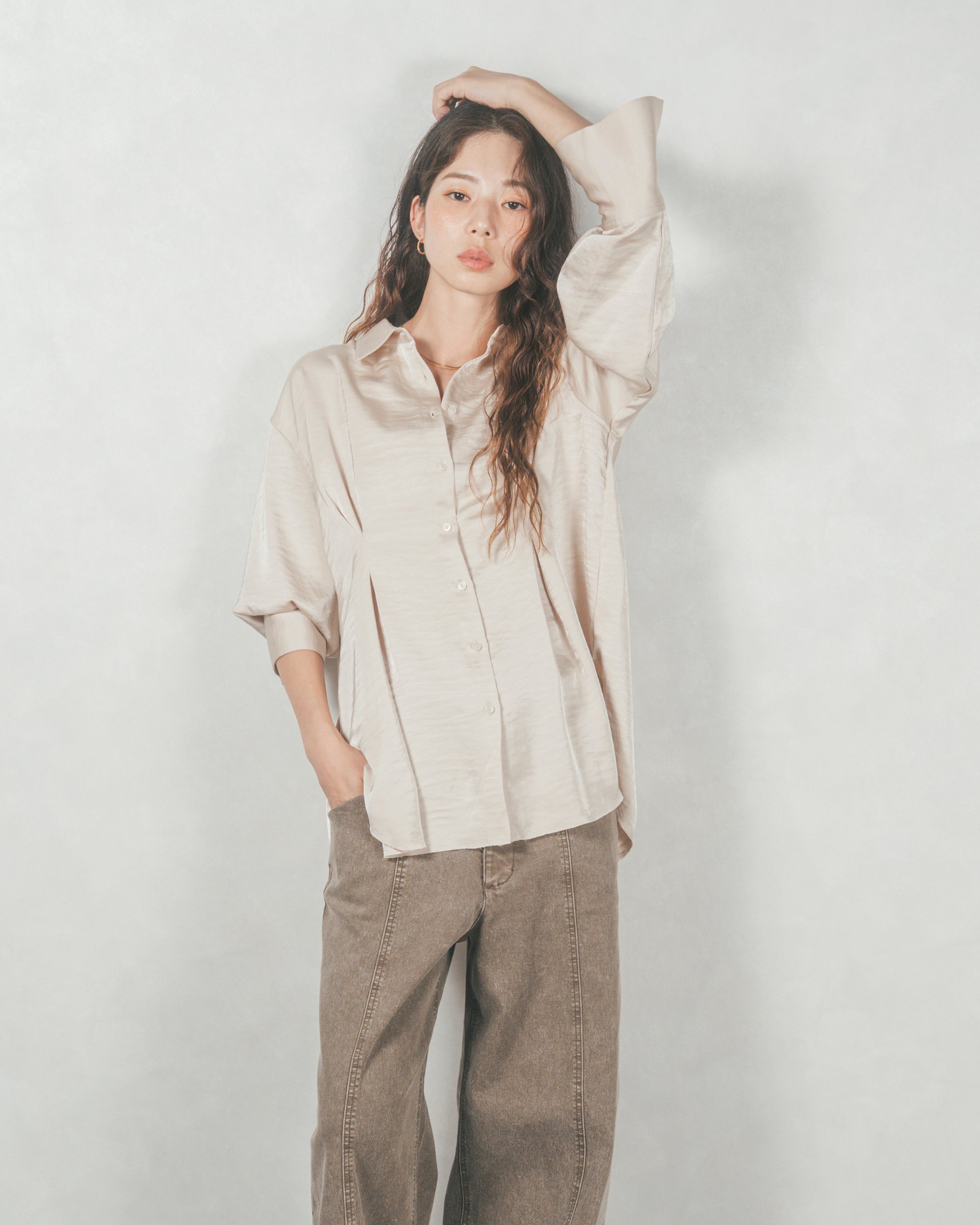 アイボリーのマットサテンシャツとブラウンのワイドパンツを合わせた、こなれ感のある大人カジュアルコーディネート。