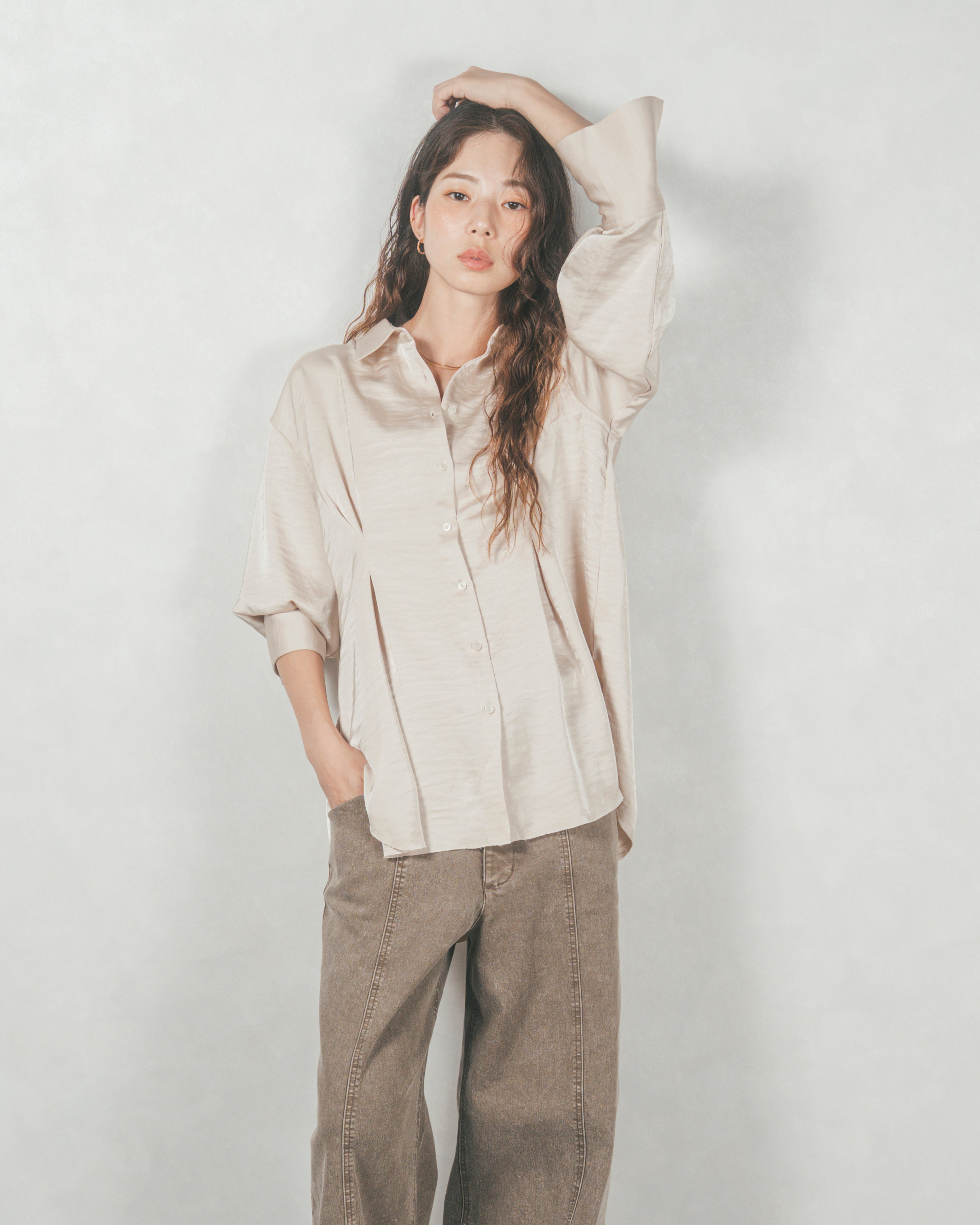 アイボリーのマットサテンシャツとブラウンのワイドパンツを合わせた、こなれ感のある大人カジュアルコーディネート。